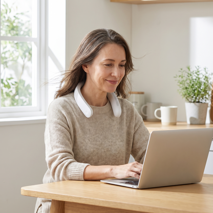 Woman working at her kitchen table wearing the Covelle neck fan